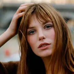 La it girl con su mano en el pelo, mirada intensa y labios entreabiertos, irradia un estilo icónico.