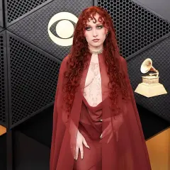 Chappell Roan, con su cabello rojo rizado y un atuendo transparente, posa en la alfombra de los Grammy.