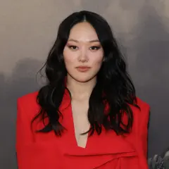 Yerin Ha, con su cabello oscuro y un elegante traje rojo, posa con confianza.