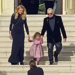 Cameron Diaz camina de la mano con su hija y su esposo por unas escaleras adornadas con flores.