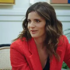 Ana Iris Simón, con su chaqueta roja, comparte ideas en una conversación animada.