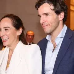 Tamara Falcó e Iñigo Onieva sonríen juntos, ella con un elegante traje blanco y él con chaqueta azul.