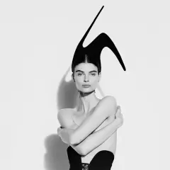 Mujer con tocado escultural negro, evocando la audacia de Elsa Schiaparelli.