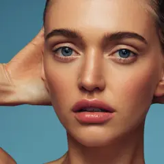Rostro de mujer con piel radiante y labios jugosos. El retinol ayuda a renovar la piel, revelando su luminosidad natural.