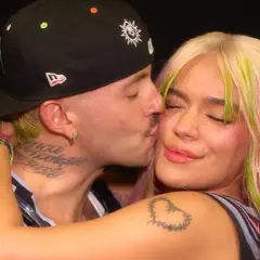 Feid le da un tierno beso a Karol G, capturando un momento íntimo entre los artistas.