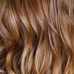 Cabello castaño con mechas babylight sutiles que aportan luz y dimensión, creando un efecto natural y radiante.