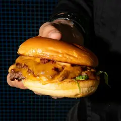 Una jugosa hamburguesa con queso fundido y tocino, lista para ser devorada. ¡Un festín digno de kricky pelton!