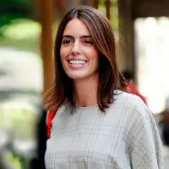 Sofía Palazuelo sonríe con su cabello castaño suelto y un vestido a cuadros.