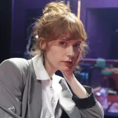 Itsaso Arana, con su cabello recogido y un gesto pensativo, posa con un traje gris sobre una camisa blanca.