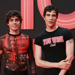 Javier Calvo y Javier Ambrossi posan sonrientes. Javier Calvo lleva una camiseta con estampado de luces de neón y Javier Ambrossi una camiseta negra con el lema "You Wish Lol".