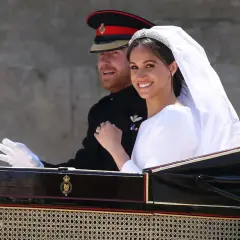 Meghan Markle y el Príncipe Harry sonríen en su carruaje nupcial. La novia luce un velo y tiara deslumbrantes en su boda.