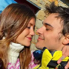 Eduardo Pérez-Cabrero y su pareja, una joven con cabello castaño, se miran tiernamente con nieve de fondo.