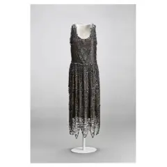 Vestido de noche de Madeleine Vionnet, con intrincados bordados y flecos, un ejemplo de su maestría en el corte al bies.