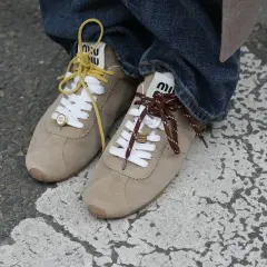 Zapatillas Miu Miu de ante beige, con cordones amarillos y marrones, un toque de zapatillas tendencia.