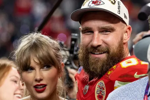 Travis Kelce, con gorra de campeones, sonríe junto a Taylor Swift, celebrando un momento especial.