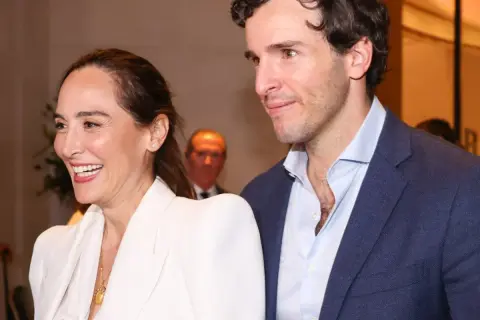 Tamara Falcó e Iñigo Onieva sonríen juntos, ella con un elegante traje blanco y él con chaqueta azul.