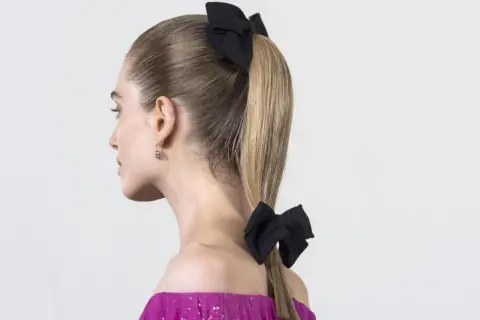 Coleta para invitada boda con dos lazos negros. Un peinado elegante y moderno, perfecto para una ocasión especial.