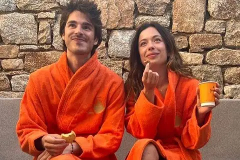 Anna Castillo y su pareja disfrutan de un momento relajado con batas naranjas, galletas y café.
