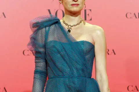Carolina Adriana Herrera luce un elegante vestido azul con lunares rojos y un collar dorado.