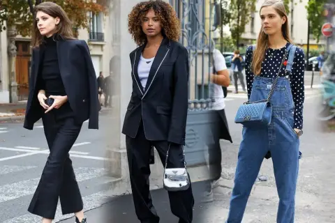 Tres mujeres exhiben su **street style** en la ciudad: una con traje negro, otra con blazer y pantalón, y la tercera con peto vaquero y top de lunares.