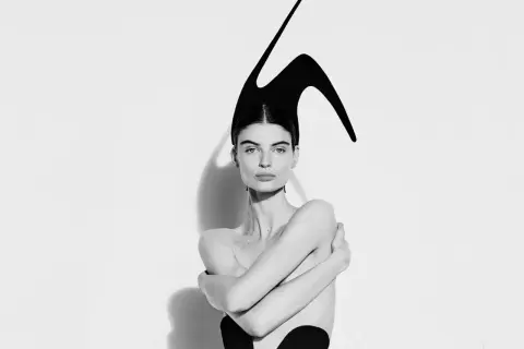 Mujer con tocado escultural negro, evocando la audacia de Elsa Schiaparelli.