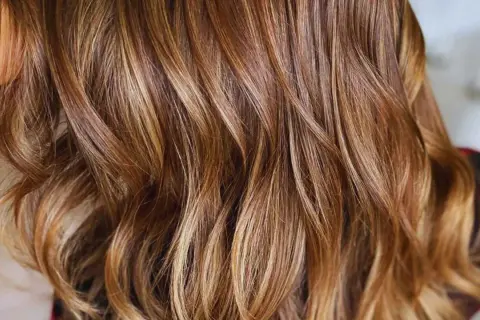 Cabello castaño con mechas babylight sutiles que aportan luz y dimensión, creando un efecto natural y radiante.