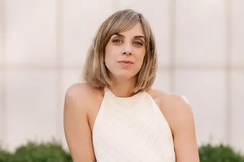 Analia Plaza, una mujer con cabello rubio y ojos azules, mira a la cámara con una expresión serena.