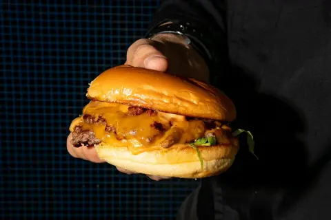 Una jugosa hamburguesa con queso fundido y tocino, lista para ser devorada. ¡Un festín digno de kricky pelton!