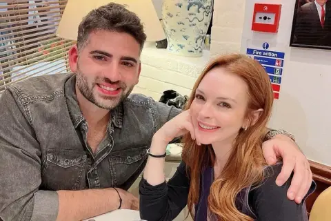 Bader Shammas y Lindsay Lohan sonríen a la cámara, compartiendo un momento íntimo.
