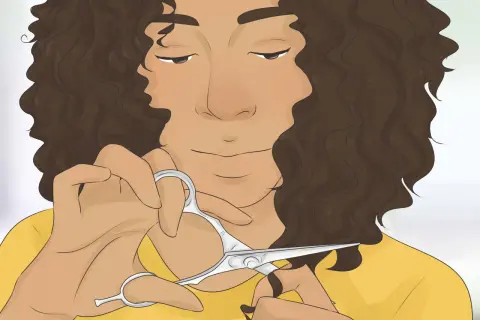 Mujer con cabello castaño rizado a capas, cortándose el pelo con tijeras.
