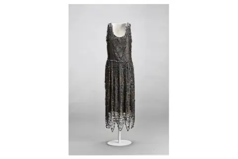Vestido de noche de Madeleine Vionnet, con intrincados bordados y flecos, un ejemplo de su maestría en el corte al bies.