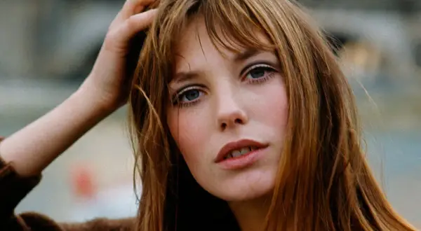 La it girl con su mano en el pelo, mirada intensa y labios entreabiertos, irradia un estilo icónico.