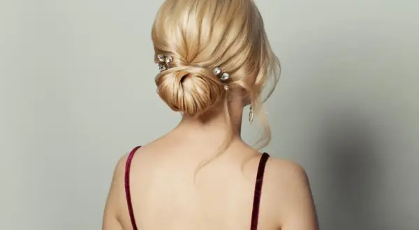 Moño bajo elegante con horquillas de cristal, ideal como peinado para invitada de boda.