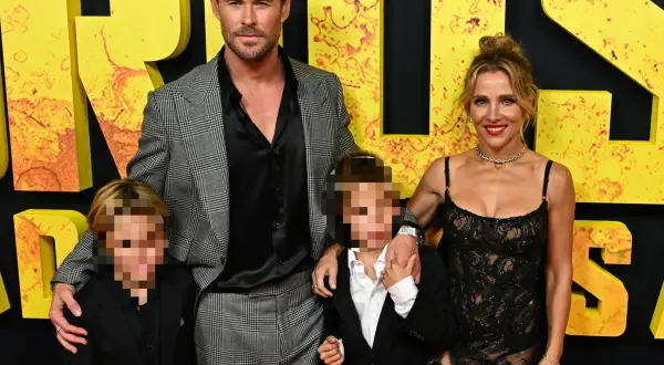 Chris Hemsworth con su esposa e hijos, los hijos de Chris Hemsworth, posan en una alfombra amarilla.