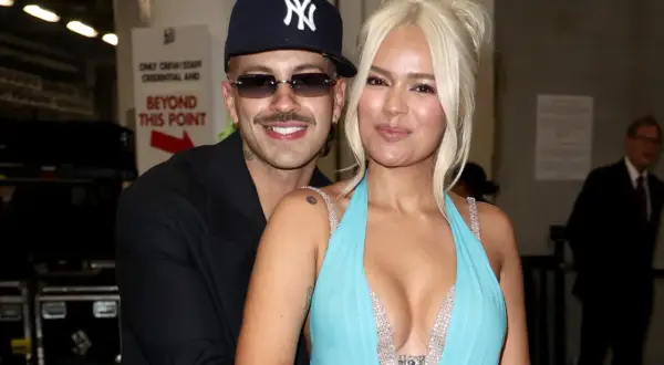 El novio de Karol G, Feid, abraza a la cantante mientras posan juntos.
