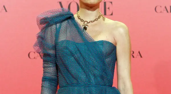 Carolina Adriana Herrera luce un elegante vestido azul con lunares rojos y un collar dorado.