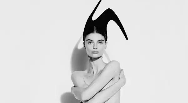 Mujer con tocado escultural negro, evocando la audacia de Elsa Schiaparelli.