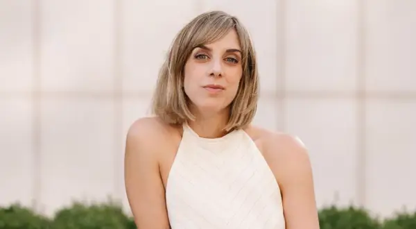Analia Plaza, una mujer con cabello rubio y ojos azules, mira a la cámara con una expresión serena.