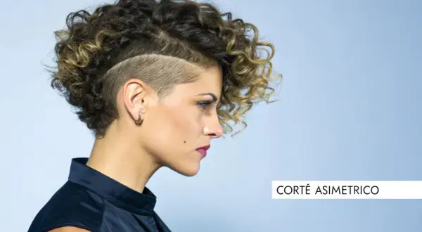 Mujer con pelo corto rizado y rapado asimétrico, luciendo un estilo audaz y moderno.