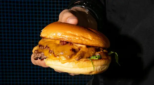 Una jugosa hamburguesa con queso fundido y tocino, lista para ser devorada. ¡Un festín digno de kricky pelton!