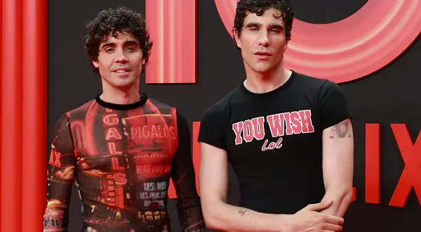 Javier Calvo y Javier Ambrossi posan sonrientes. Javier Calvo lleva una camiseta con estampado de luces de neón y Javier Ambrossi una camiseta negra con el lema "You Wish Lol".