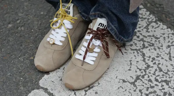 Zapatillas Miu Miu de ante beige, con cordones amarillos y marrones, un toque de zapatillas tendencia.