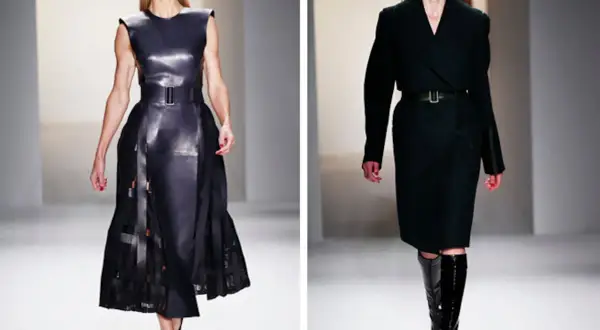 Modelos desfilan creaciones de Calvin Klein (diseñador): un vestido de cuero negro con falda plisada y un conjunto de abrigo y falda en tono oscuro con botas altas.