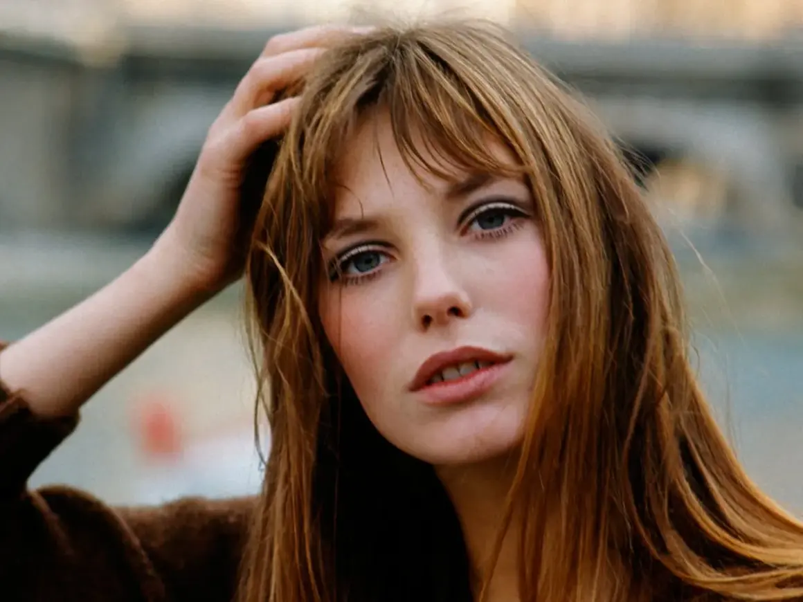La it girl con su mano en el pelo, mirada intensa y labios entreabiertos, irradia un estilo icónico.