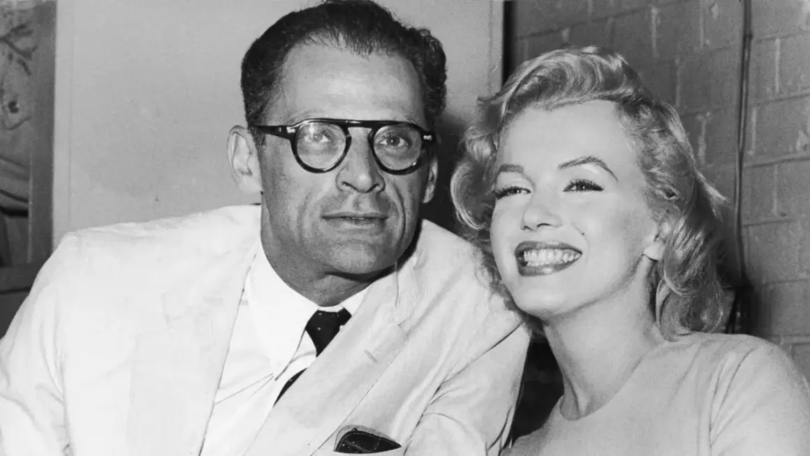 Marilyn Monroe sonríe junto a su cónyuge, Arthur Miller, un dramaturgo con gafas.