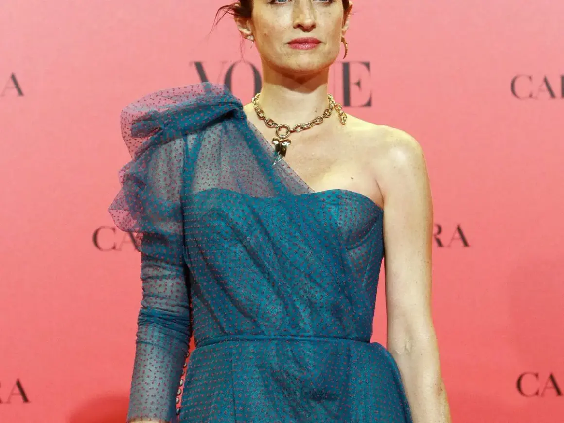 Carolina Adriana Herrera luce un elegante vestido azul con lunares rojos y un collar dorado.