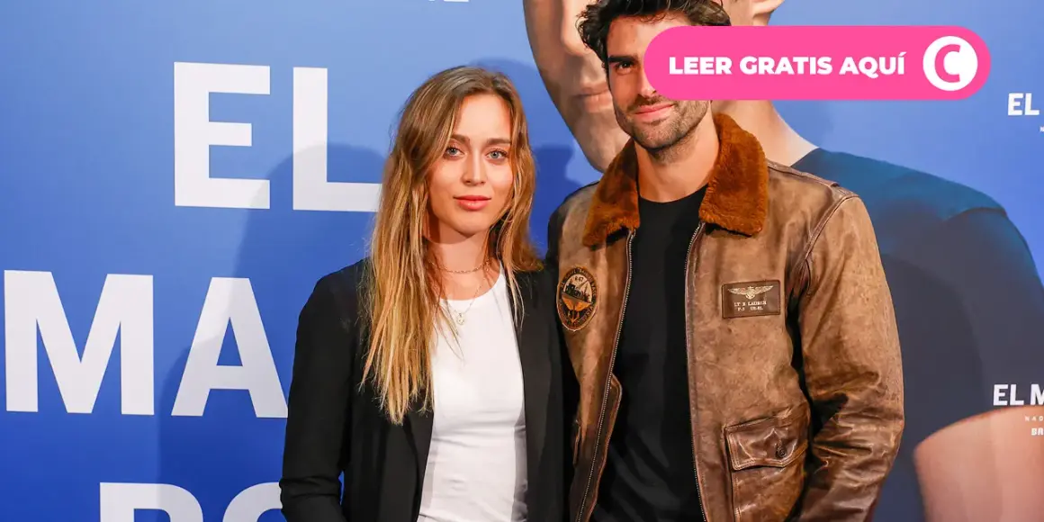 Paula Badosa y su novio posan sonrientes ante un fondo azul con letras blancas.
