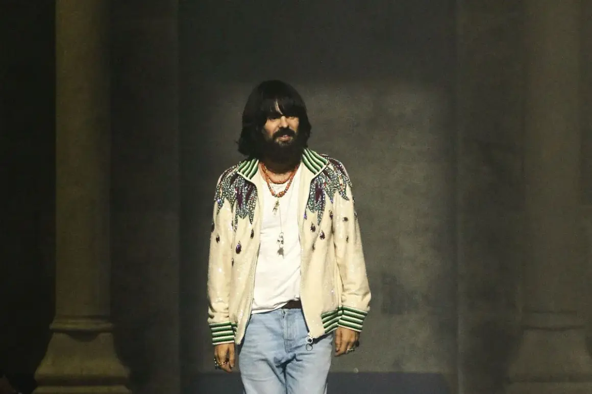 Alessandro Michele, con su icónico estilo, luce una chaqueta bordada y jeans.