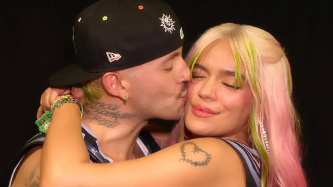 Feid le da un tierno beso a Karol G, capturando un momento íntimo entre los artistas.