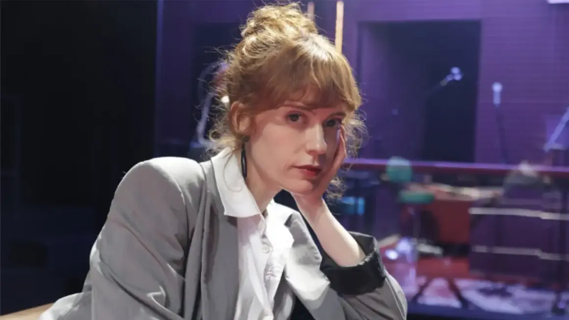 Itsaso Arana, con su cabello recogido y un gesto pensativo, posa con un traje gris sobre una camisa blanca.